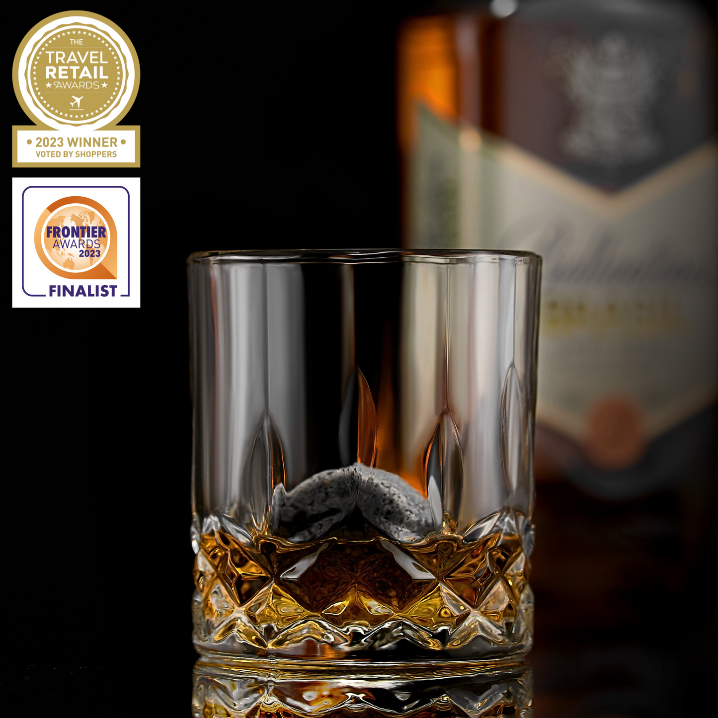 Whiskey connoisseur glass gift set signature edition — premium Father's Day gift for dad Glass of whiskey with a blurred bottle in the background, featuring awards on the left.